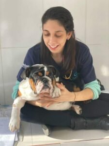Dra Ana sorrindo com o cão no colo